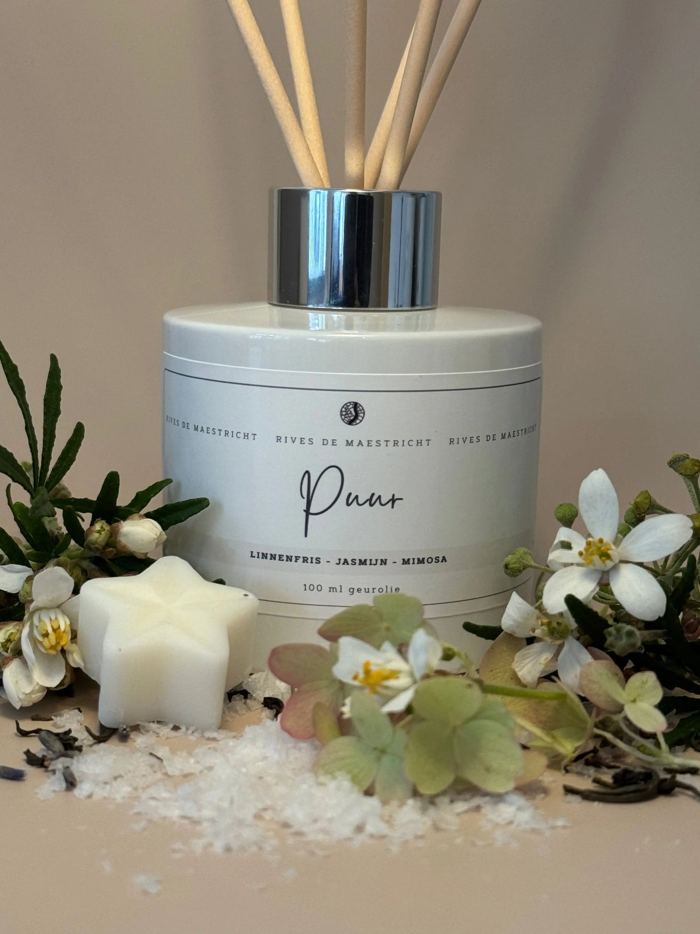 foto wit diffuser flesje met naturel geurstokjes clean cotton met witte bloemen zout en beige achtergrond - geurstokjes Puur - merk Rives de Maestricht