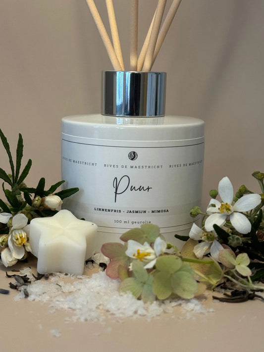 foto wit diffuser flesje met naturel geurstokjes clean cotton met witte bloemen zout en beige achtergrond - geurstokjes Puur - merk Rives de Maestricht