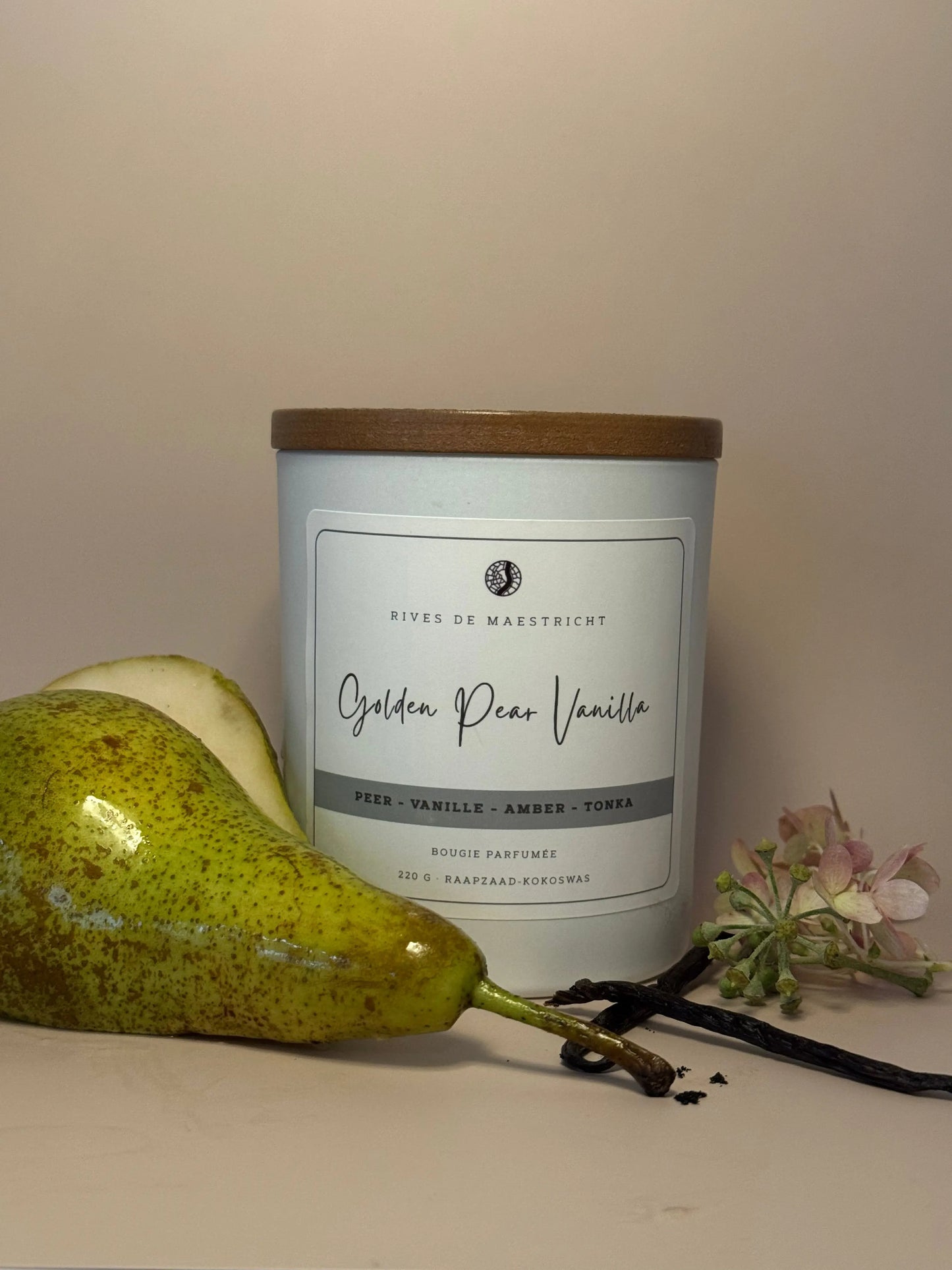 een witte kaarsenpot met peer ernaast geurkaars peer en vanille - Golden Pear and vanilla - Rives de Maestricht
