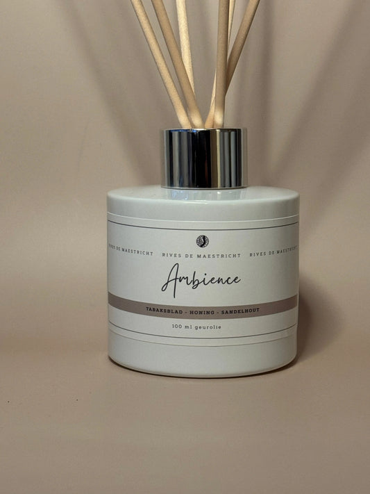 foto wit diffuser flesje met naturel geurstokjes met beige achtergrond - geurstokjes Ambience - merk Rives de Maestricht